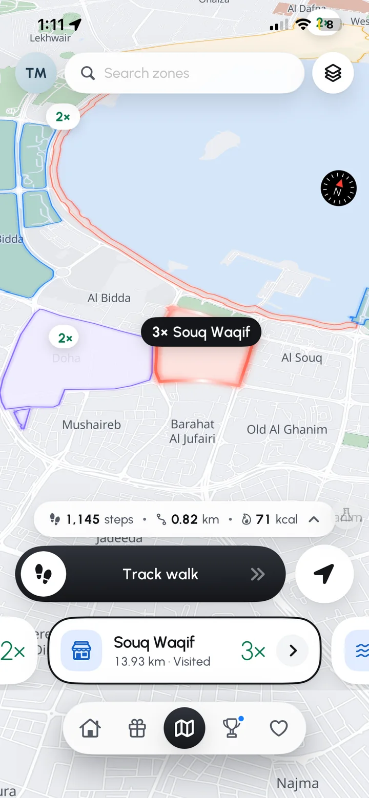 The Emshi app's map screen over Doha's Corniche: the Souq Waqif booster zone outlined in red at three times the points, double-points zones around it, 1,145 steps and 0.82 km walked today, and the Track walk button ready.